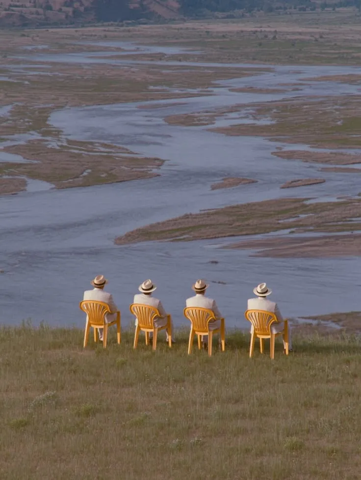 Empty chairs facing a wide quiet landscape